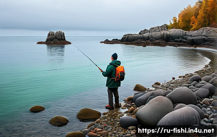 가을철 쭈꾸미 낚시 팁 - A serene autumn fishing scene on a rocky shoreline with gentle waves, featuring a fisherman dressed ...